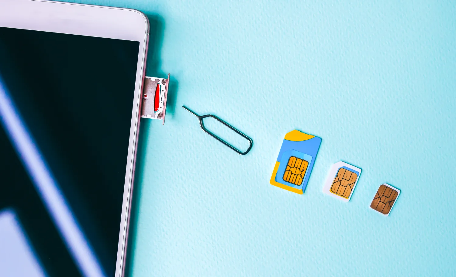 Smartphone mit Micro- und Nano-SIM-Karten auf Tisch – Symbolbild für den Umstieg auf eSIM Thailand und moderne Mobilfunktechnologien.
